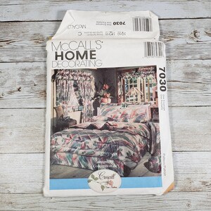 May include: A McCall's Home Decorating pattern envelope featuring a bedroom design by Croscill. The pattern includes a bed with a quilted bedspread, pillows, and curtains. The pattern number is 7030.