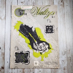 May include: A vintage sheet music cover for "Waltzes No. 2" by Irving Berlin. The cover features a black and white illustration of a woman's gloved hand holding a white rose. The text "for voice and piano" is printed in black on a white background.