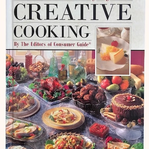 May include: A cookbook titled "The Treasury of Creative Cooking" with a cover showing a table laden with food, including a roasted chicken, pasta, and a chocolate cake. The image includes text and a small inset photo.