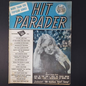 May include: A vintage magazine cover for Hit Parader, featuring a photo of Veronica Lake, a popular actress of the 1940s. The cover features a blue background with white text and a list of popular songs from the era. The magazine cover is dated November 1946.