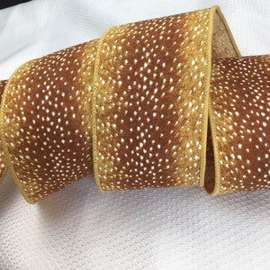May include: A roll of brown and white patterned ribbon with a white polka dot design. The ribbon has a satin finish and is perfect for crafting and decorating.