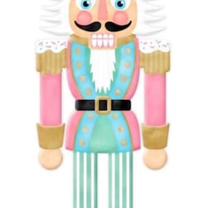 May include: A pink and blue nutcracker with a white beard and gold accents. The nutcracker has a black hat with white sprinkles and a pink and white cupcake on top.