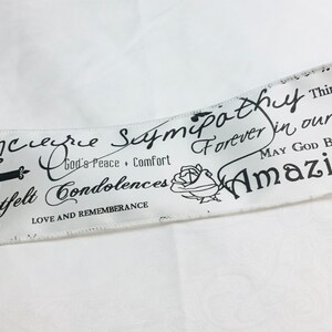 Biały satynowy nadruk z wyrazami współczucia