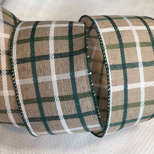 May include: A roll of brown, white, and green plaid ribbon. The ribbon has a woven texture and is perfect for crafting and decorating.