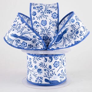 Op de afbeelding: Een decoratieve lintrol met een witte achtergrond en een blauw bloemen- en vogelpatroon. Het lint heeft een blauwe rand en is geschikt voor knutselen, cadeauverpakking en decoratieve doeleinden. Afmetingen in centimeters.