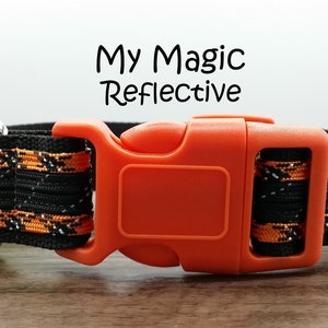 May include: A black and orange dog collar with a reflective strip and an orange plastic buckle. The collar has the text "My Magic Reflective" printed on it.
