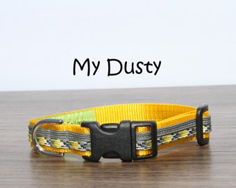 Puede incluir: Collar de perro amarillo con una hebilla negra y un anillo en D plateado. El collar tiene un patrón de rayas grises y blancas. El texto "My Dusty" está escrito encima del collar.