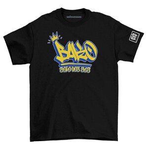 May include: Black t-shirt featuring a graffiti-style design in yellow and blue. The design includes the word "BARO" with a crown and the text "SOLOVOSSOS" below. A small logo is on the right sleeve. The brand name "solovossos" is printed on the collar.