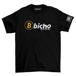 May include: Black t-shirt with a Bitcoin logo and the word "bicho" in white. The Bitcoin symbol is a gold-colored "B" inside a gold circle. The text "SOLO VOS SOS" is below the word "bicho". A white square logo is on the right sleeve.
