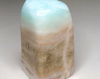 May include: A light blue and brown banded polished stone with a smooth, rounded surface.
