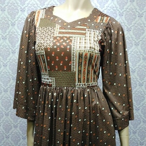 May include: A brown midi dress with a patchwork design on the bodice and a white and brown polka dot pattern on the skirt.