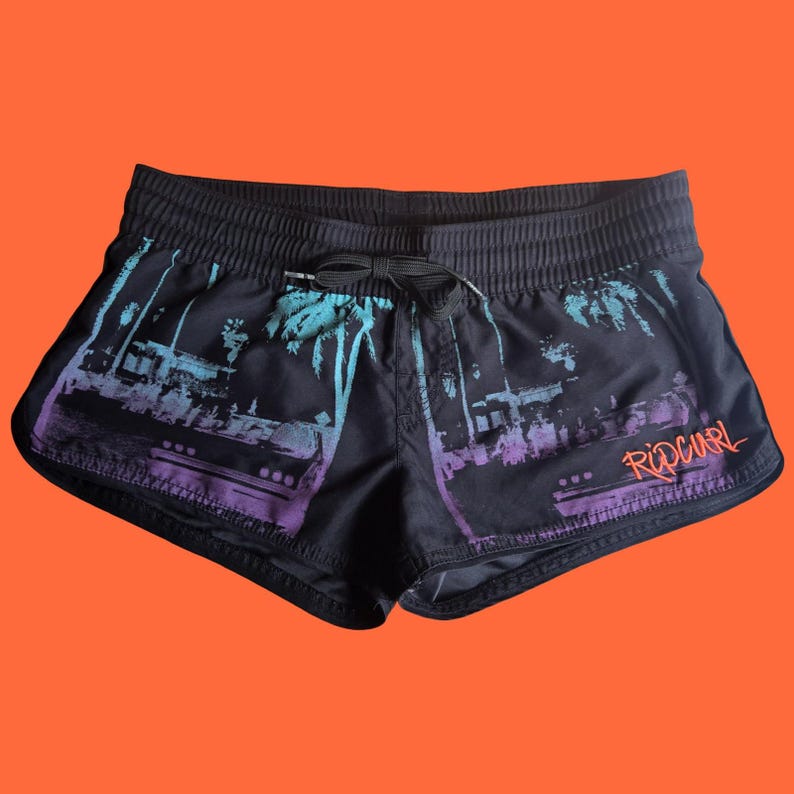 Op de afbeelding: Zwarte zwemshort met een tropisch ontwerp in teal en paars. De short heeft een tailleband met trekkoord en het Rip Curl-logo in oranje. Gemaakt van lichtgewicht materiaal.