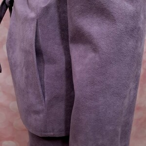 May include: A purple suede jacket with a long sleeve and a pocket on the side.