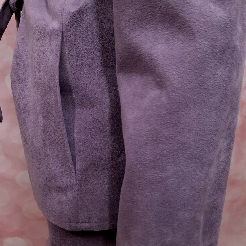May include: A purple suede jacket with a long sleeve and a pocket on the side.