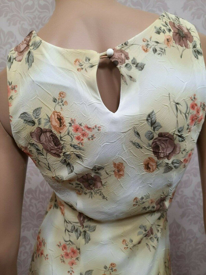 May include: A sleeveless dress with a floral print in shades of brown, pink, and yellow. The dress has a keyhole opening at the back of the neckline.