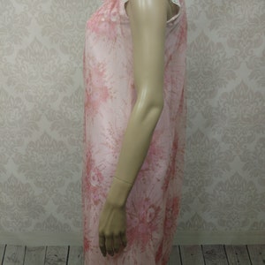 Pode incluir: Camisola de noite vintage rosa floral, com mangas curtas e uma delicada barra de renda. O tecido transparente apresenta um padr&atilde;o floral repetido em tons de rosa e vermelho. A camisola de noite &eacute; exibida em um manequim.