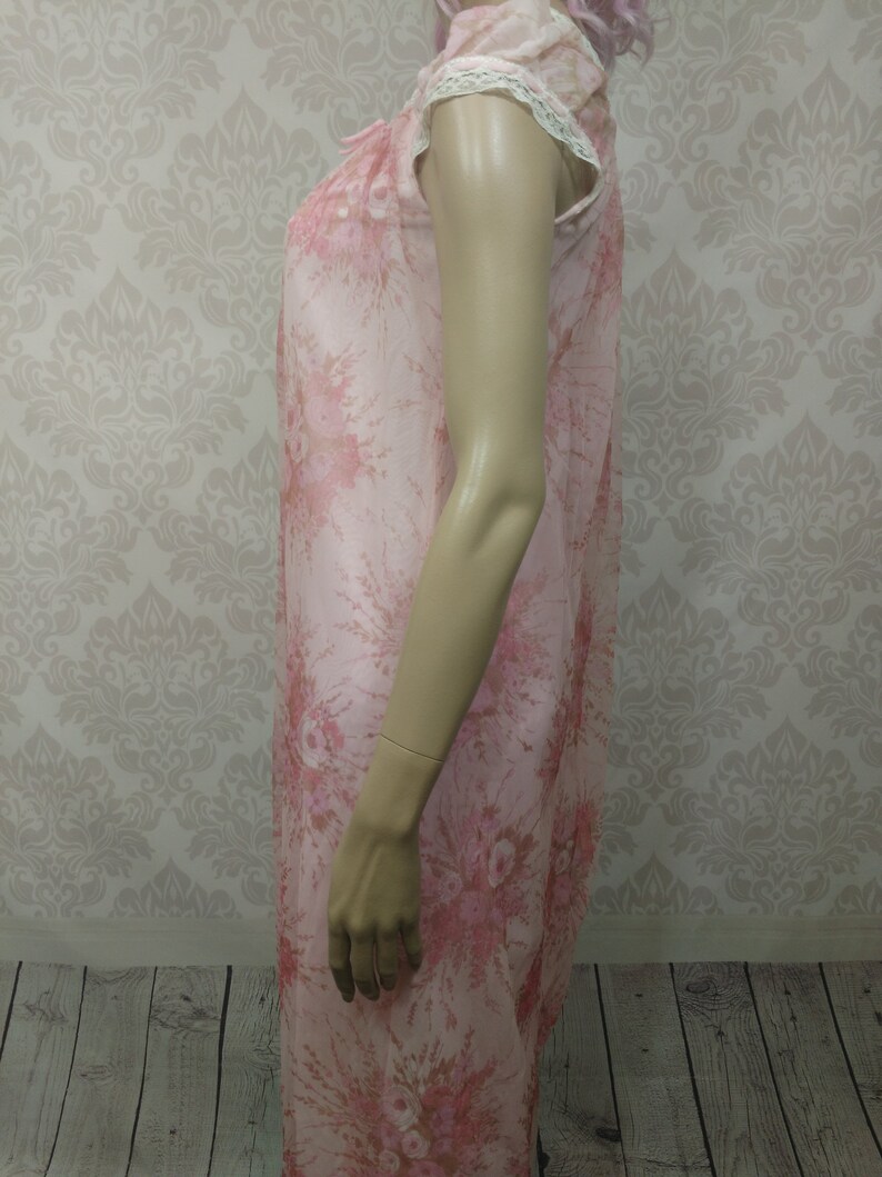 Pode incluir: Camisola de noite vintage rosa floral, com mangas curtas e uma delicada barra de renda. O tecido transparente apresenta um padr&atilde;o floral repetido em tons de rosa e vermelho. A camisola de noite &eacute; exibida em um manequim.