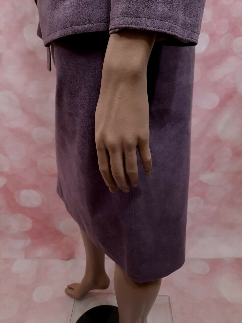 May include: A purple suede skirt with a straight silhouette and a slightly flared hem.
