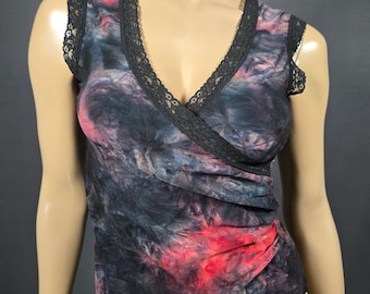 May include: A sleeveless wrap top with a V-neckline. The top features a tie-dye pattern in shades of black, red, and blue. Black lace trim accents the neckline and armholes. The fabric appears to be a soft, lightweight material.