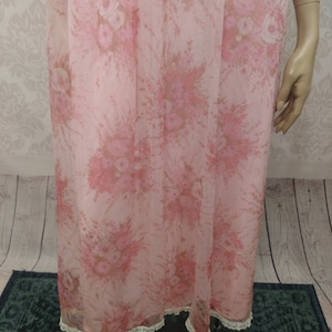 Pode incluir: Camisa de noite vintage rosa claro com um padr&atilde;o floral em tons de rosa e castanho. A camisa de noite apresenta uma delicada renda na bainha. O tecido parece leve e fluido, sugerindo um ajuste confort&aacute;vel.