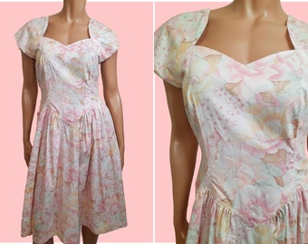May include: A pink and white floral print dress with a sweetheart neckline and short sleeves. The dress has a fitted bodice and a full skirt.