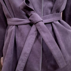 May include: A purple robe with a self-tie sash. The robe is made of a soft, plush fabric.