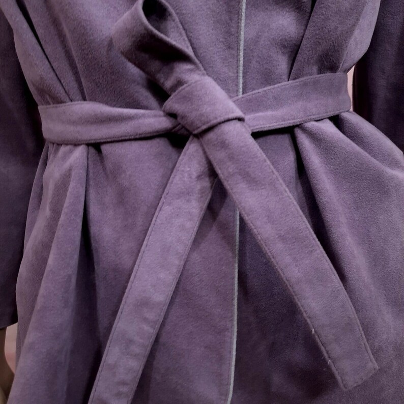 May include: A purple robe with a self-tie sash. The robe is made of a soft, plush fabric.