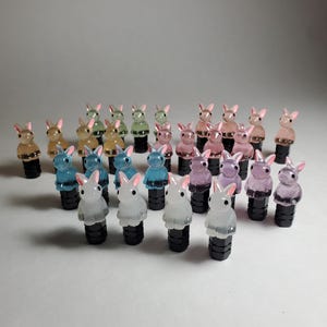 May include: A collection of 20 colorful rabbit-shaped tire valve stem caps. The caps are made of clear plastic and come in a variety of colors, including pink, blue, green, and white.