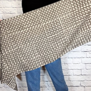 May include: A gray and white patterned scarf with a white polka dot design. The scarf has a border with a geometric pattern.