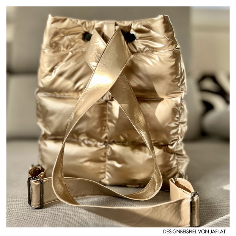 May include: A gold metallic backpack with a quilted design. The bag has adjustable shoulder straps and a drawstring closure. The backpack is made of a shiny, padded material and has a rectangular shape. The bag is shown from the back.
