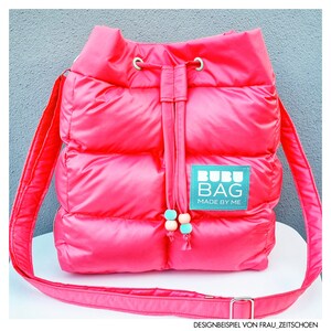 May include: A vibrant pink quilted shoulder bag with a drawstring closure and a long strap. The bag has a rectangular label with the text "BUBU BAG MADE BY ME". The drawstring has decorative beads.