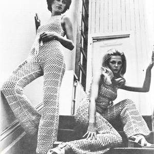 May include: Two women wearing matching crochet jumpsuits with a geometric pattern. The jumpsuits have wide legs and are sleeveless. The women are posing on a staircase.