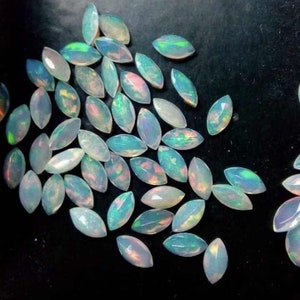 以下が含まれることがあります： 虹色の虹色の光沢を持つ、白いオパールマルキーズの宝石のコレクション。石は緩んでおり、ジュエリーにセットする準備ができています。