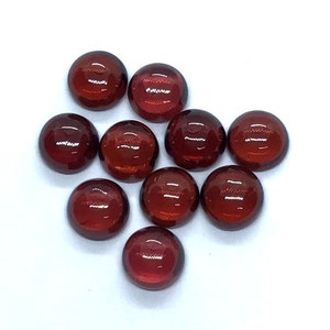 Può includere: Dieci cabochon rotondi di pietra preziosa rossa. I cabochon sono lisci e lucidi.