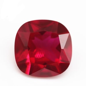 Könnte beinhalten: Ein tiefroter Kissen-Schliff-Edelstein mit einer facettierten Oberfläche.