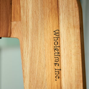 May include: A close-up of a wooden cutting board with the text "Wholetime Inc." engraved on the side.