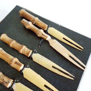 Puede incluir: Conjunto de seis pinchos de c&oacute;ctel de bamb&uacute; y madera en una caja negra. Los pinchos tienen un acabado de madera natural y est&aacute;n dise&ntilde;ados para servir aperitivos o bocadillos.
