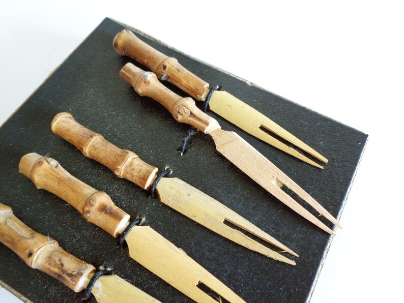 Puede incluir: Conjunto de seis pinchos de c&oacute;ctel de bamb&uacute; y madera en una caja negra. Los pinchos tienen un acabado de madera natural y est&aacute;n dise&ntilde;ados para servir aperitivos o bocadillos.