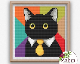 May include: A cross-stitch pattern featuring a black cat with yellow eyes, wearing a white collar and a yellow necktie. The background is divided into geometric sections of orange, green, teal, purple, and red. The frame is light wood.