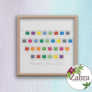May include: A cross-stitch pattern for a calendar with colorful squares representing each day of the month. The calendar is for May 2022 and is personalized with the name "Elisabeth".