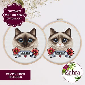 Puede incluir: Dos patrones de punto de cruz con caras de gato con ojos azules, cada uno en un aro de madera. Uno está etiquetado como "Juliet" y el otro como "Romeo" en una pancarta con flores rojas. El texto "¡Personaliza con el nombre de tu gato!" está arriba.