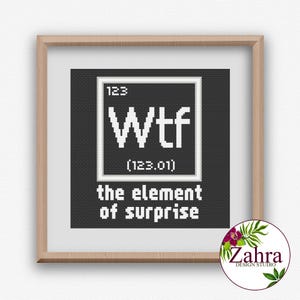 May include: A framed print with a black background features the word "Wtf" in white, styled like a periodic table element. Below, it reads "the element of surprise." The frame is light brown.