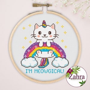 Może przedstawiać: Biały kot z rogiem jednorożca siedzący na tęczy z chmurami i tekstem "I'm Meowgical!"