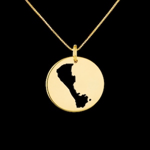 May include: Gold necklace with a round pendant featuring a cut-out silhouette of the country of Peru.