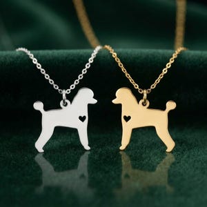 Puede incluir: Dos collares con colgantes en forma de caniche, uno en tono plateado y otro en tono dorado. Cada colgante tiene un pequeño corazón recortado en el cuerpo y está suspendido de una delicada cadena de eslabones metálicos a juego.