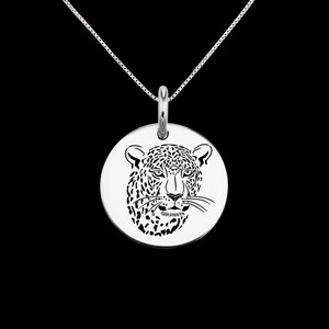 May include: A silver necklace with a round pendant featuring a detailed cutout design of a leopard's face.