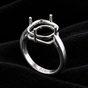 Peut inclure: Une monture de bague en argent sterling poli dotée d'une tête à quatre griffes conçue pour maintenir une pierre précieuse de taille coussin. L'anneau est lisse et arrondi, avec le poinçon 925 gravé sur la surface intérieure.