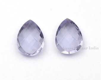 May include: Two clear, faceted amethyst teardrop-shaped gemstones. The gemstones are a light purple color and have a smooth, polished finish.