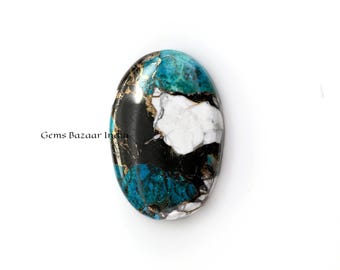 May include: A close-up of a turquoise, black, and white oval cabochon gemstone with gold flecks. The gemstone is set against a white background.