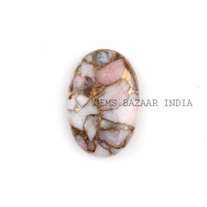 May include: Oval shaped cabochon gemstone with a pink and white base and gold flecks. The stone is a mix of pink, white, and gold.